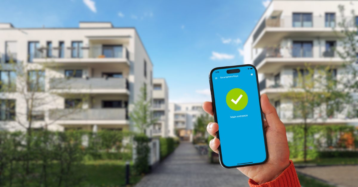 Hand with a smartphone in front of residential buildings